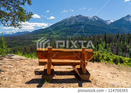 Scenic Wooden Bench Overlooking the Canadian Rockies. Summer mountain valley vista in Jasper National Park, Alberta, Canada. Cabin Lake Loop Trail. Scenic Wooden Bench Overlooking the Canadian Rockies. Summer mountain valley vista in Jasper National Park, Alberta, Canada. Cabin Lake Loop Trail. 124708365