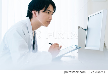 A young doctor operating a computer A young doctor operating a computer 124708741