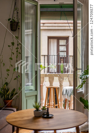 Cozy home interior view leading to a charming balcony with plants and an inviting atmosphere Cozy home interior view leading to a charming balcony with plants and an inviting atmosphere 124709877