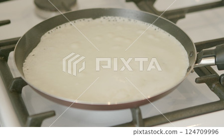 Cooking Pancakes on a Stove A Delicious Preparation for a Tasty Breakfast Meal Cooking Pancakes on a Stove A Delicious Preparation for a Tasty Breakfast Meal 124709996