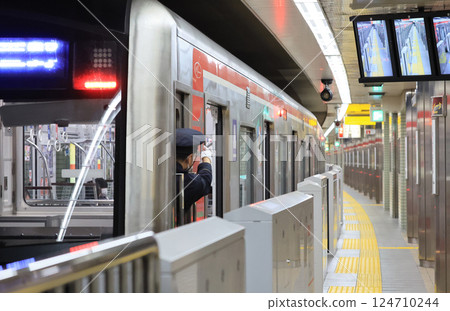Osaka Metro 30000 series train and conductor at Nakamozu Station 124710244