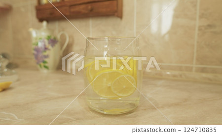 Enjoying Refreshing Lemon Water Served in a Beautiful Glass Jar Perfect for Summer Days Enjoying Refreshing Lemon Water Served in a Beautiful Glass Jar Perfect for Summer Days 124710835