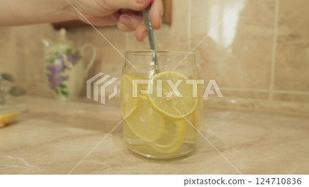 Enjoying Refreshing Lemon Water Served in a Beautiful Glass Jar Perfect for Summer Days Enjoying Refreshing Lemon Water Served in a Beautiful Glass Jar Perfect for Summer Days 124710836