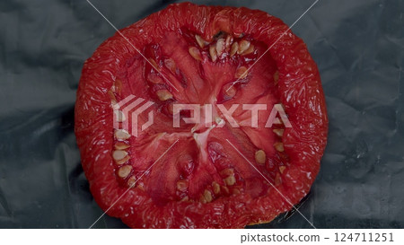 A Slice of Ripe, Juicy Tomato Presented on a Dark Background, Perfect for Culinary Use 124711251