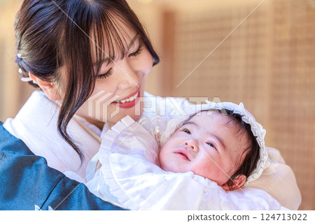 A mother gazing at her child at a shrine visit 124713022