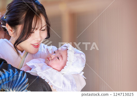 A mother gazing at her child at a shrine visit 124713025