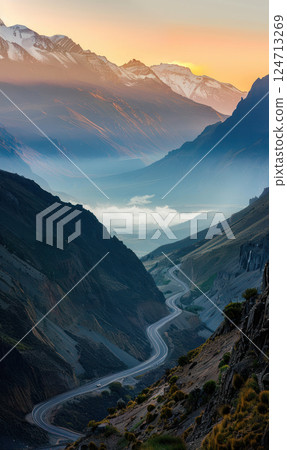 A winding road leads into misty mountains under a glowing sunset sky. Generate AI 124713269