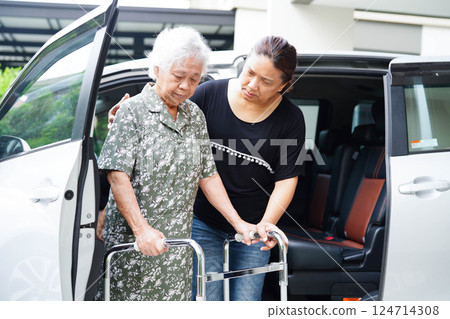 Caregiver help Asian elderly woman disability patient get in her car. 124714308