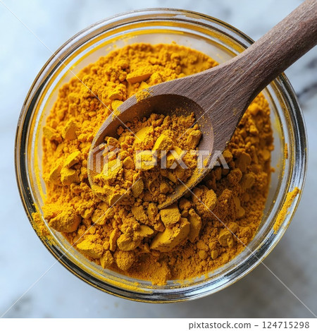 Vibrant turmeric spice in wooden spoon - culinary ingredient for health and flavor enhancement Vibrant turmeric spice in wooden spoon - culinary ingredient for health and flavor enhancement 124715298