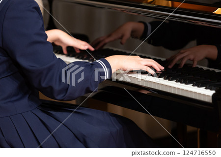 Hands of a female student in a sailor suit playing the piano 124716550