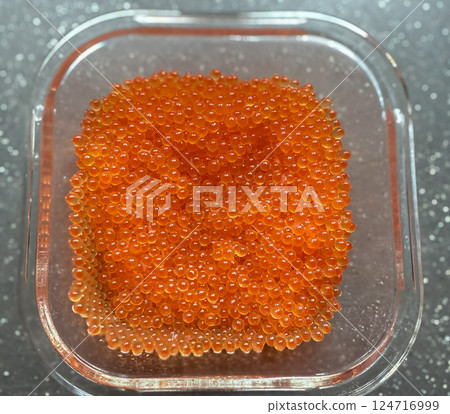 Close-up of a spoon with appetizing red caviar against the background of many caviar eggs. Seafood delicacies, top view Close-up of a spoon with appetizing red caviar against the background of many caviar eggs. Seafood delicacies, top view 124716999