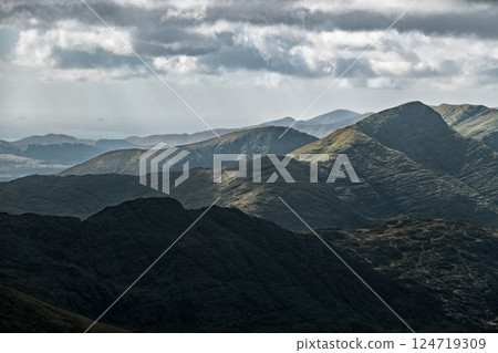 The image shows a detailed view of a mountain range. Varied shades of dark greens and greys indicate different rock formations and vegetation. The sky is overcast. The image shows a detailed view of a mountain range. Varied shades of dark greens and greys indicate different rock formations and vegetation. The sky is overcast. 124719309
