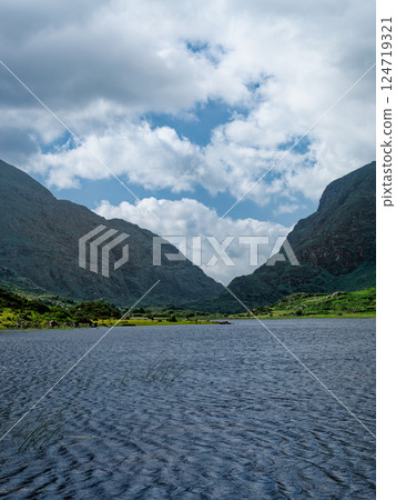 Majestic Black Lake in Ireland surrounded by stunning mountain landscapes under a vibrant sky. 124719321