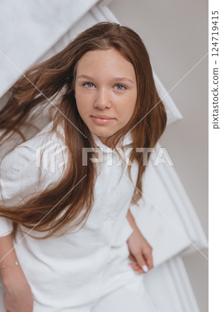 Adorable happy teenager girl in white shirt at home Adorable happy teenager girl in white shirt at home 124719415