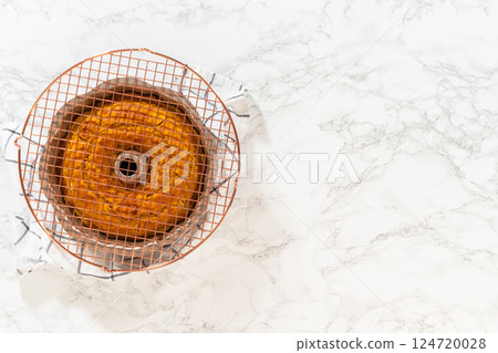 Flat lay. Cooling freshly baked pumpkin bundt cake on the kitchen counter. Flat lay. Cooling freshly baked pumpkin bundt cake on the kitchen counter. 124720028