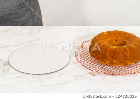 Icing the pumpkin bundt cake with cream cheese frosting and decorating it with chocolate leaves. 124720029