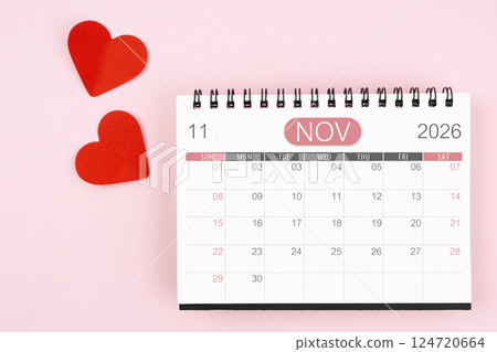 Red heart with November 2026 desk calendar on pink background. 124720664