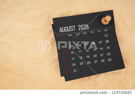 Black calendar for August 2026 with thumbtack on brown paper. 124720685