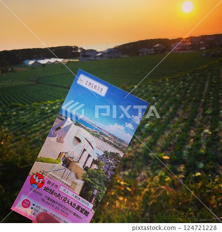 充滿旅行靈感的鄉村場景,在日落和田野的背景下高舉旅遊手冊 充滿旅行靈感的鄉村場景,在日落和田野的背景下高舉旅遊手冊 124721228