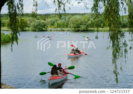 Kayaking adventure on a calm lake surrounded by lush greenery during a sunny afternoon in the countryside 124721557