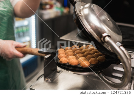 Making delicious takoyaki in a busy kitchen with a skilled chef at work behind the counter during lunchtime Making delicious takoyaki in a busy kitchen with a skilled chef at work behind the counter during lunchtime 124721586