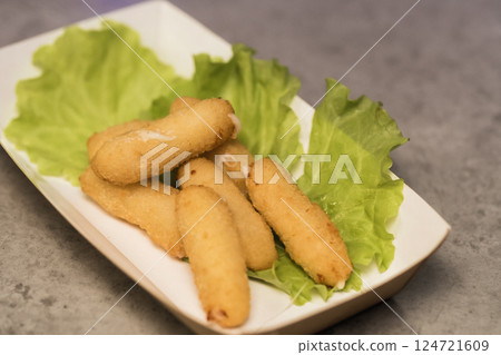 Deliciously crispy fried snacks served on a bed of fresh lettuce in a cozy dining setting during an evening meal 124721609