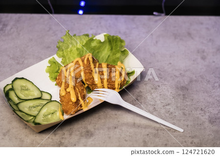 Delicious fried chicken served with lettuce and cucumber slices at a local outdoor food market during evening hours Delicious fried chicken served with lettuce and cucumber slices at a local outdoor food market during evening hours 124721620