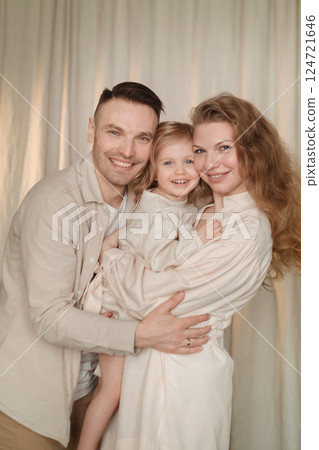 Family poses together with joy in a cozy indoor setting during a serene moment captured at home 124721646