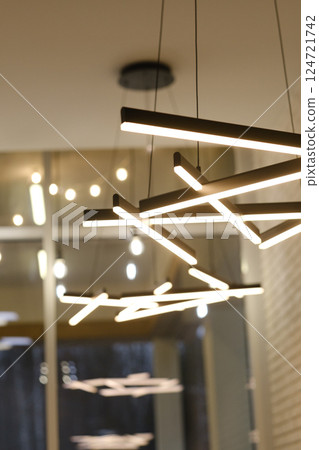 Modern lighting fixtures create a warm and inviting atmosphere in a contemporary interior space during the evening 124721742