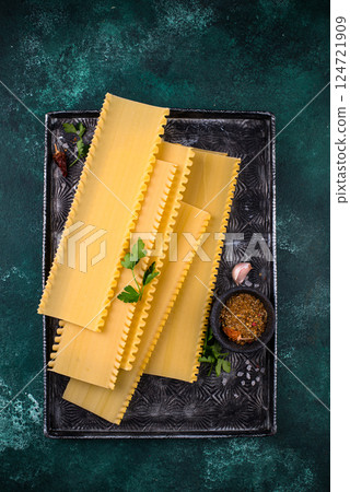 Uncooked lasagna pasta with cooking ingredient Uncooked lasagna pasta with cooking ingredient 124721909