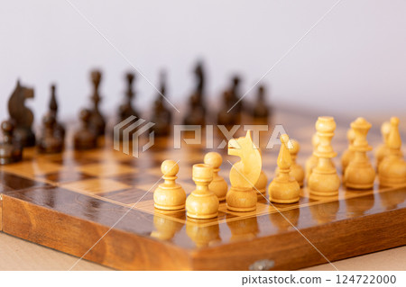 Wooden white chess pieces on the chessboard 124722000