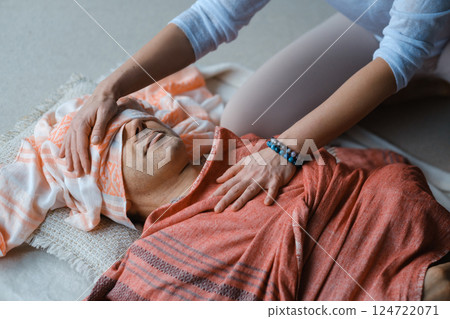 Relaxation and healing through gentle massage in a serene indoor setting during a wellness session 124722071