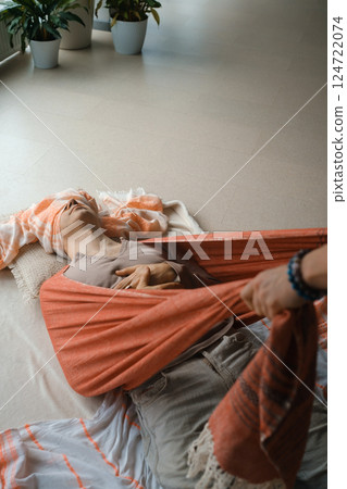 Relaxation and healing during a restorative yoga session with supportive props in a serene indoor environment 124722074