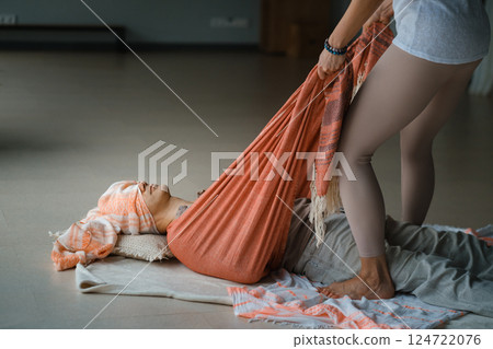 Relaxation and healing during a restorative yoga session with supportive props in a serene indoor environment Relaxation and healing during a restorative yoga session with supportive props in a serene indoor environment 124722076