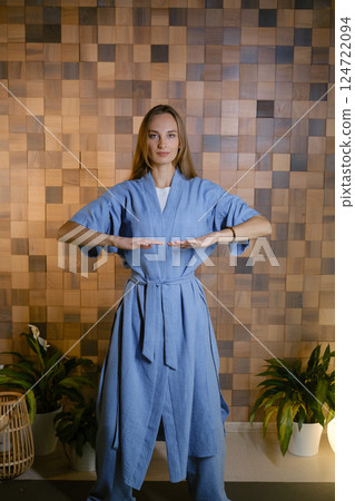 Girl in blue kimano practicing kundalini or qigong yoga in fitness gym . Spiritual energy, life force located at the base of the spine Girl in blue kimano practicing kundalini or qigong yoga in fitness gym . Spiritual energy, life force located at the base of the spine 124722094