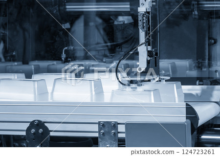 Close up scene material handling process the food container by robotic system from injection machine. Close up scene material handling process the food container by robotic system from injection machine. 124723261