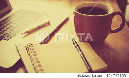 Coffee break with open notebook and laptop on desk 124724163