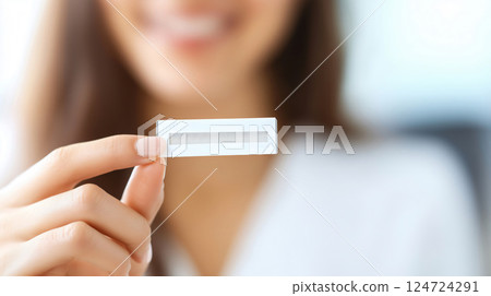 Beautician is holding an hormonal test strip, showing it to the camera, hormonal Devices Beautician is holding an hormonal test strip, showing it to the camera, hormonal Devices 124724291