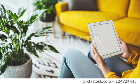 Woman holding tablet with blank screen in cozy apartment 124724435