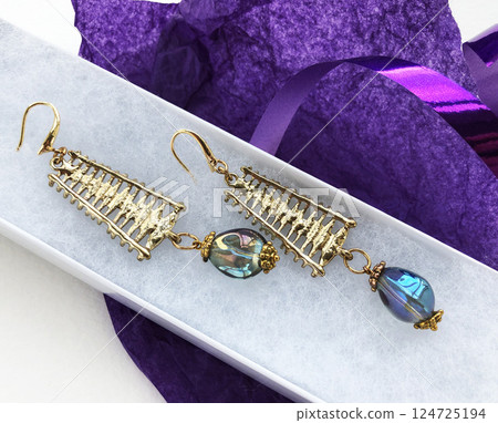 Unique earrings for women on a purple background, promotional photo for an online vintage and handmade jewelry store 124725194