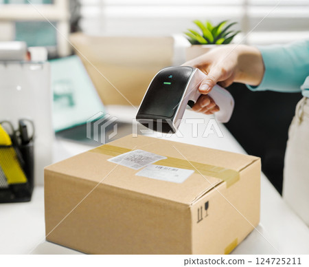 The employee scans the QR code of the parcel at the online order pick-up point 124725211