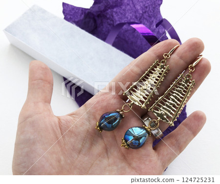 Unique earrings for women on a purple background, promotional photo for an online vintage and handmade jewelry store Unique earrings for women on a purple background, promotional photo for an online vintage and handmade jewelry store 124725231
