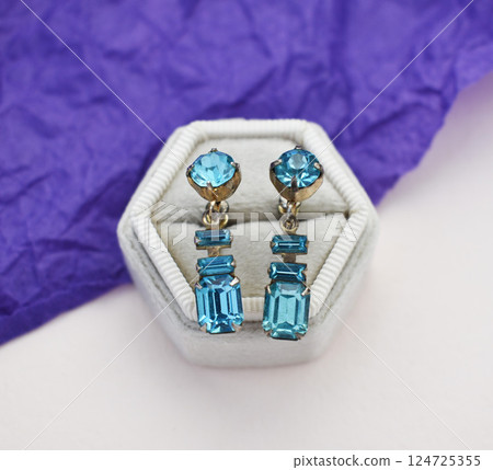 Unique earrings for women on a purple background, promotional photo for an online vintage and handmade jewelry store Unique earrings for women on a purple background, promotional photo for an online vintage and handmade jewelry store 124725355