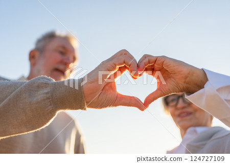 Love heart shape peace. Senior older couple making heart shape with their hands. Adult mature old husband wife showing heart sign. Happy pensioner family. I love you happy valentines day 124727109