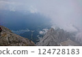Zugspitze, Germany - 6.17.2018: Breathtaking view from the summit overlooking a dramatic landscape with rugged peaks shrouded in mist and Eibsee reflecting the cloudy sky 124728183