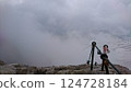 Zugspitze, Germany - 6.17.2018: Mist envelops the rocky summit of Zugspitze, with metal cables and colorful tokens flapping in the wind, representing climbers' journeys at the highest peak in Germany 124728184