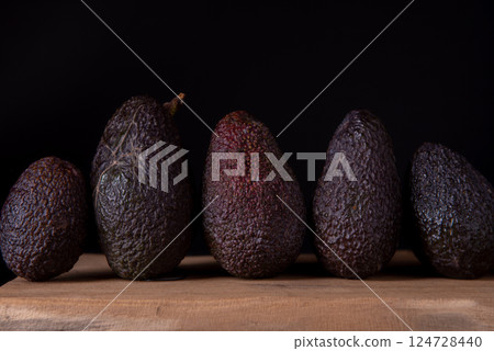 Five Hass avocados on wooden table. 124728440