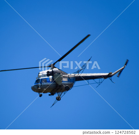 A helicopter of agricultural aviation is flying in the blue sky. A helicopter of agricultural aviation is flying in the blue sky. 124728502