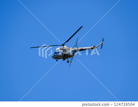 A helicopter of agricultural aviation is flying in the blue sky. A helicopter of agricultural aviation is flying in the blue sky. 124728504