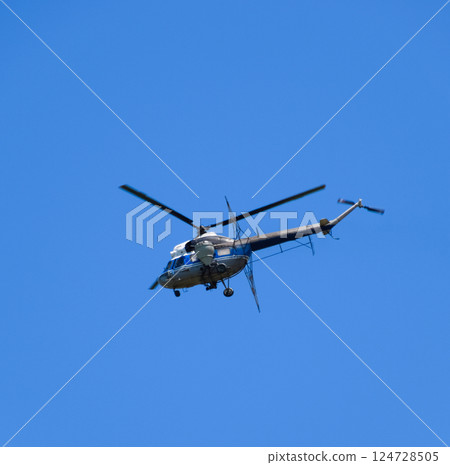 A helicopter of agricultural aviation is flying in the blue sky. A helicopter of agricultural aviation is flying in the blue sky. 124728505